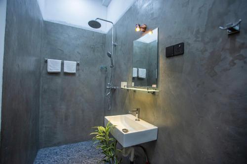 a bathroom with a sink and a shower and a mirror at Mishu House in Ahangama