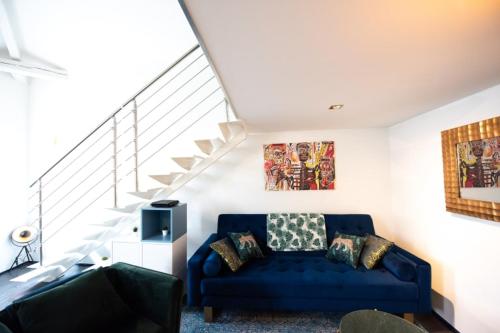 - un salon avec un canapé bleu et des escaliers dans l'établissement Maison triplex JJ - Ecrin verdoyant au coeur de Lyon, à Lyon