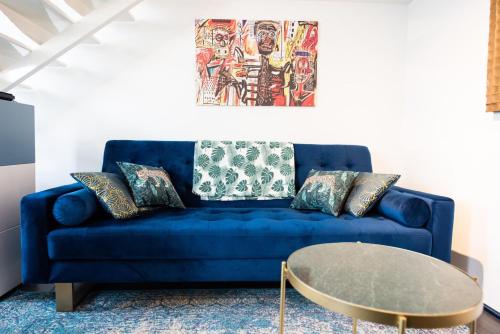 - un canapé bleu avec des oreillers et une table dans la chambre dans l'établissement Maison triplex JJ - Ecrin verdoyant au coeur de Lyon, à Lyon