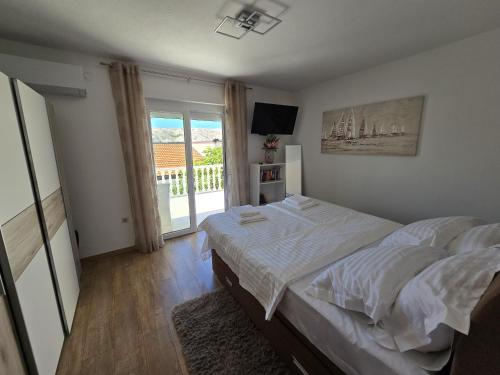 a bedroom with a bed and a large window at Apartment Benda in Pag