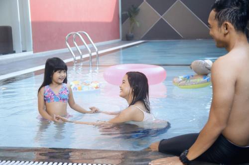 a group of people in a swimming pool at favehotel Rungkut Surabaya in Surabaya