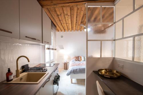 - une cuisine avec évier et un lit dans une chambre dans l'établissement Sainte Hélène - Lovely high class studio, à Lyon