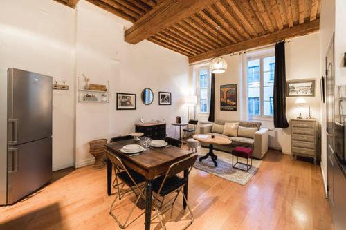 un salon avec une table et un réfrigérateur dans l'établissement Trion - quartier St Just - 42m2 Proche Vieux Lyon, à Lyon