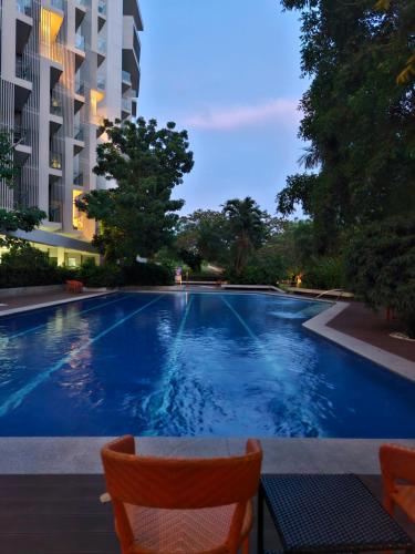 a swimming pool with two chairs and a building at Tambuli Shore Residence in Lapu Lapu City