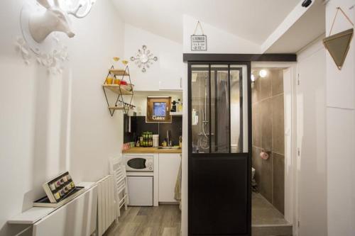 une cuisine avec une porte en verre menant à une cuisine dans l'établissement Nid du Parc - Parfait 1 personne, à Lyon