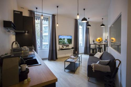 un salon avec un canapé et une télévision dans l'établissement Suite Garibaldi Cosy et Design, à Lyon