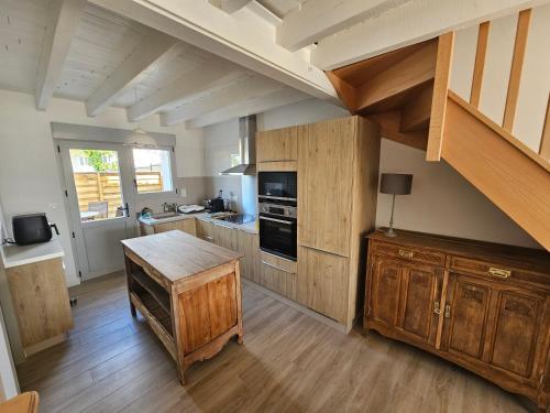 une grande cuisine avec des placards en bois et une table en bois dans l'établissement Le 6 - B Saint Xandre, à Saint-Xandre