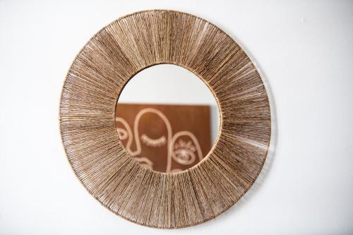 un miroir rond avec un cadre métallique sur une paroi dans l'établissement Le Moanda - Charpennes 15 mn du centre de Lyon, à Villeurbanne