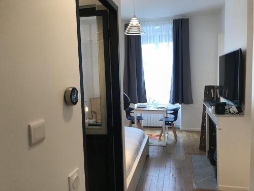 un salon avec un canapé, une table et un miroir dans l'établissement Le Joyau de Jouhaux appartement G - Lyon Garibaldi, à Lyon