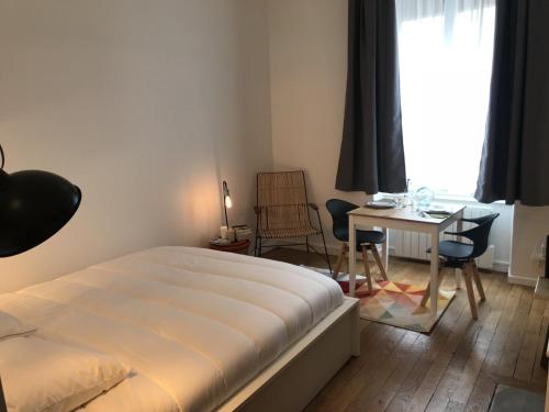 une chambre avec un lit, une table et des chaises dans l'établissement Le Joyau de Jouhaux appartement G - Lyon Garibaldi, à Lyon