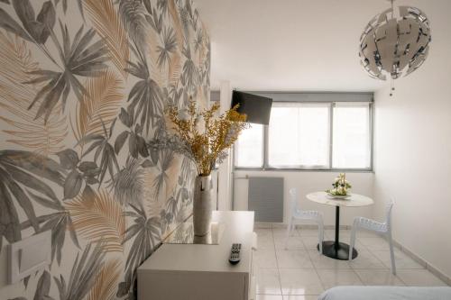 - un salon avec un vase de fleurs sur un mur dans l'établissement Le Jasseron - Appartement cosy avec garage quartier PartDieu, à Lyon