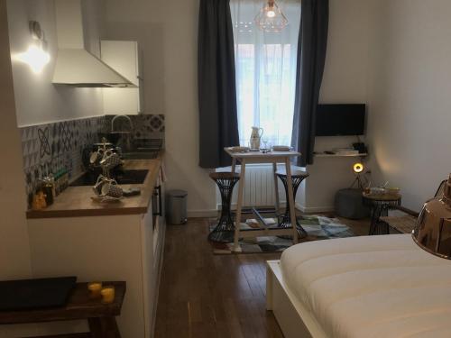 une chambre avec un lit et une cuisine avec une table dans l'établissement La Suite de Léon appartement D - Lyon Garibaldi, à Lyon