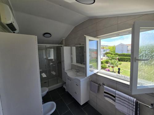 a bathroom with a sink and a window at Apartment Benda in Pag