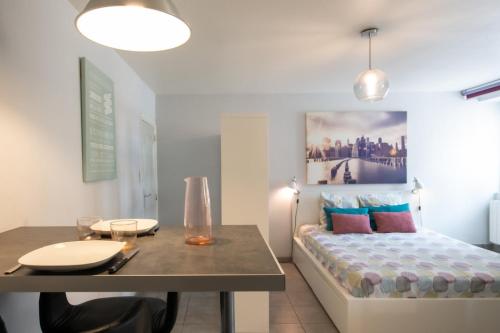 a room with a table and a bed and a table and a dining table at Le cocon des Monts d'Or in Saint-Germain-au-Mont-dʼOr