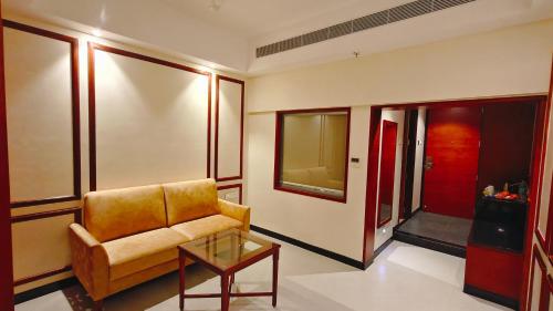 a living room with a chair and a table at MM Legacy - A Bergamont Hotel, Kanchipuram in Kanchipuram