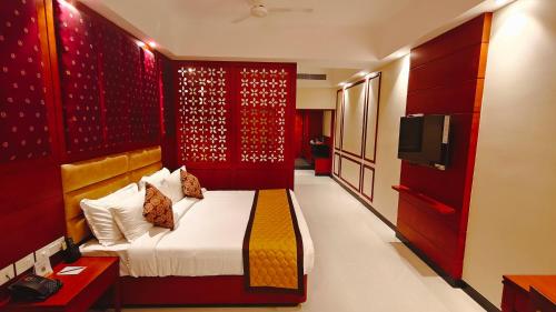 a bedroom with a bed and a television in it at MM Legacy - A Bergamont Hotel, Kanchipuram in Kanchipuram