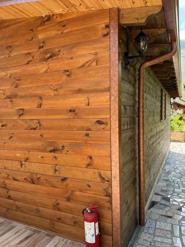 a wooden building with a fire hydrant next to it at Kantina & Ferma Dukat in Vlorë