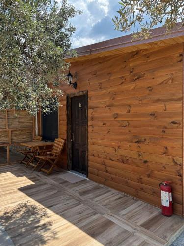 a wooden cabin with a wooden door and a patio at Kantina & Ferma Dukat in Vlorë