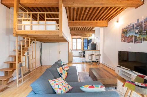 un salon avec un canapé bleu et une mezzanine dans l'établissement Soyeux - Superbe canut quai de Saône, à Lyon