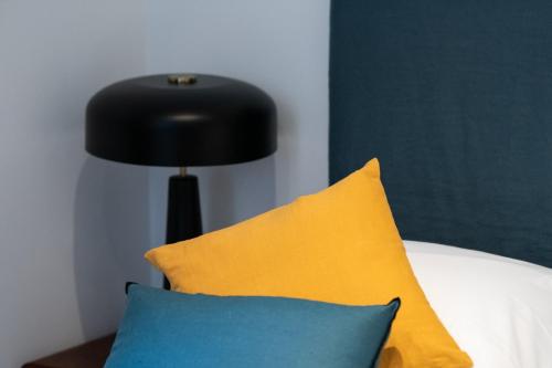 une lampe noire assise à côté d'un lit avec des oreillers dans l'établissement Opéra 8 - Superbe studio refait à neuf proche place des Terreaux, à Lyon