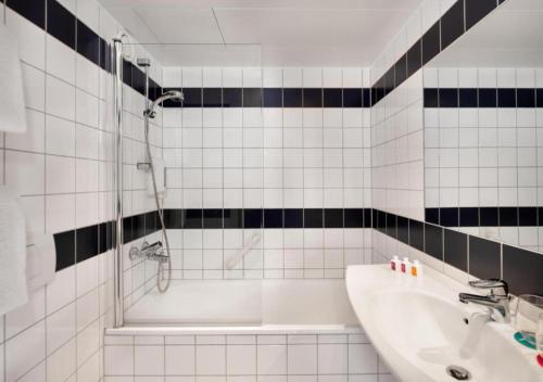 a bathroom with a tub and a sink and a shower at Quality Hotel Sarpsborg in Sarpsborg