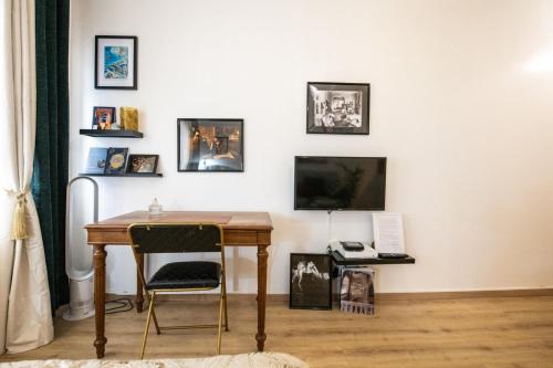 Cette chambre comprend un bureau, une télévision et une table. dans l'établissement Le Gatsby Superbe cocon cosy proche place, à Lyon