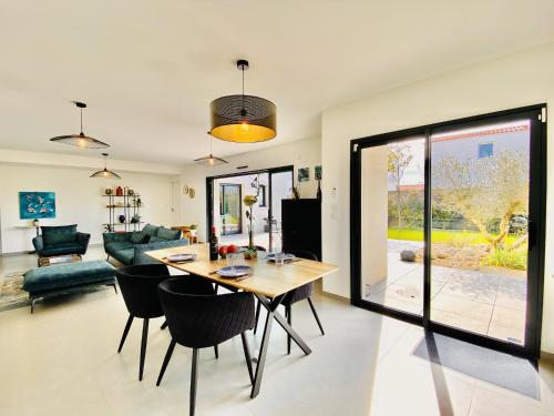 a dining room and living room with a table and chairs at Villa chic & Zen - Workation - Plage à 10min in Vaux-sur-Mer