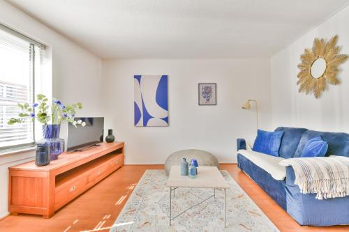 a living room with a blue couch and a tv at De Laat Vintage in Alkmaar