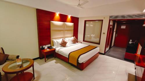 a hotel room with a bed and a table at MM Legacy - A Bergamont Hotel, Kanchipuram in Kanchipuram