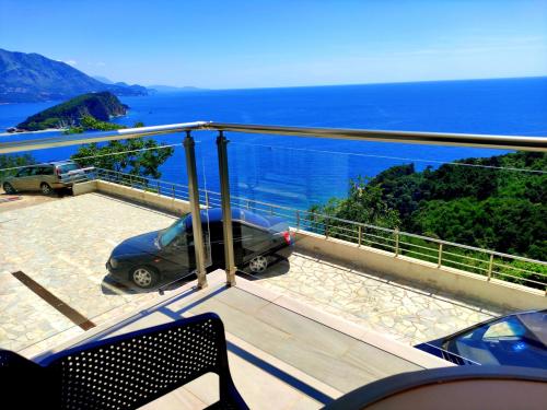 布德瓦Hillside Apartment with Infinity Pool and Sea View的海景阳台和汽车。