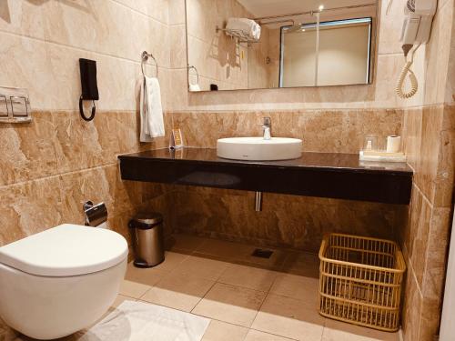 a bathroom with a toilet and a sink and a mirror at MM Legacy - A Bergamont Hotel, Kanchipuram in Kanchipuram