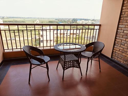 a table and chairs on a balcony with a view at MM Legacy - A Bergamont Hotel, Kanchipuram in Kanchipuram