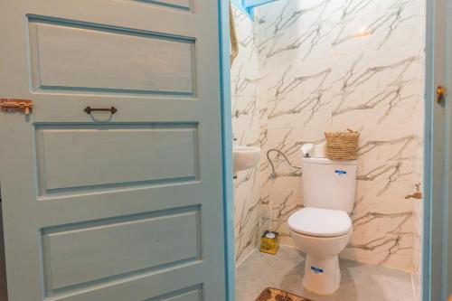 La salle de bains est pourvue de toilettes et d'une porte bleue. dans l'établissement L'authentique place, à Essaouira