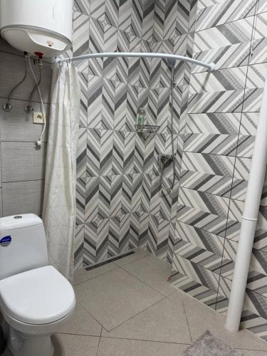 a bathroom with a toilet and a geometriciled wall at Центр Благомед Парк з Кондиціонером in Luts'k