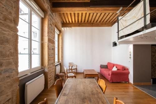 un salon avec une table et un canapé rouge dans l'établissement Le Bohème - Superbe Canut - Coeur Croix Rousse, à Lyon