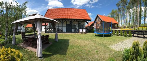 a house with a gazebo and a playground at Tomaszówka - Domek na Kaszubach in Załakowo
