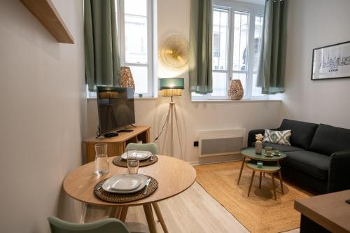 un salon avec une table et un canapé dans l'établissement L'Opéra 2 - RDC - Joli studio Hôtel de Ville, à Lyon