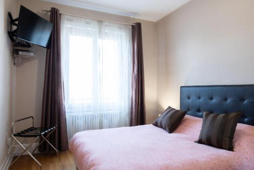 une chambre avec un lit avec une grande fenêtre dans l'établissement Le Saint Mo' - Joli appartement tout confort au coeur de Monplaisir, à Lyon