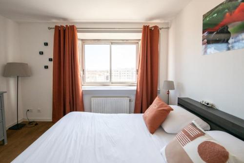 Un dormitorio con una cama blanca y una ventana. en L'Alto - Bel appartement lumineux -Vue panoramique, en Gare des Brotteaux