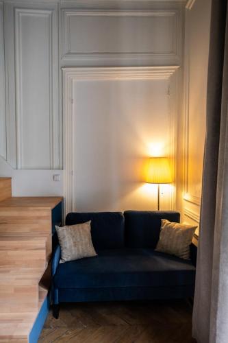 - un canapé bleu dans le salon avec une lampe dans l'établissement Le Chavannes -Ecrin élégant & Cosy - Pentes de la Croix Rousse, à Lyon