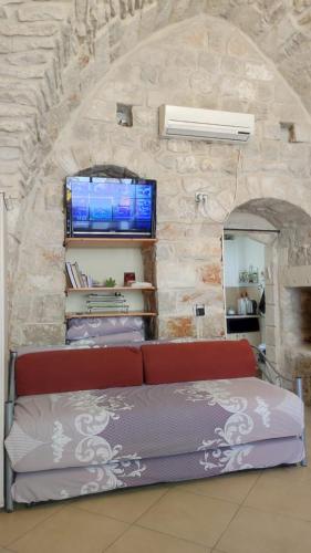 a red couch in a room with a stone wall at צימר רבי מאיר in Safed