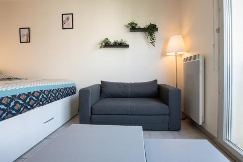 un salon avec un canapé et une chaise dans l'établissement Le Gaïa - Joli appartement au calme 10min du centre de Lyon, à Villeurbanne