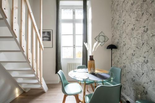 Un comedor con mesa y sillas en Le Gary - Appartement atypique refait à neuf - A deux pas Parc Tête d'Or, en Gare des Brotteaux