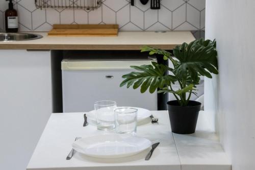une table avec une assiette, des verres et une plante dans l'établissement Le Paul B - Green, à Lyon