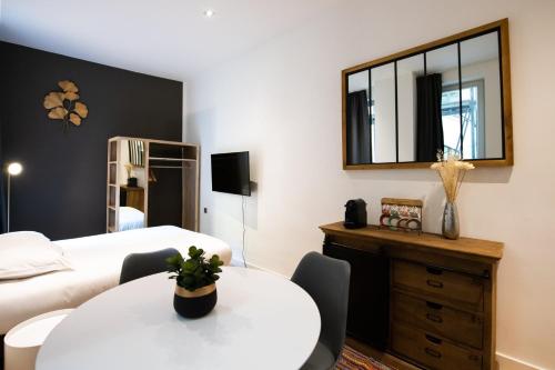 - une chambre avec une table blanche et un miroir dans l'établissement Le St Germain - Pétillant studio décoré avec goût en centre-ville, à Lyon