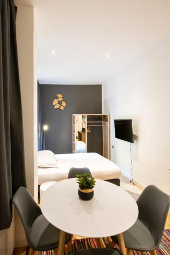 Cette petite chambre comprend une table et 2 lits. dans l'établissement Le St Germain - Pétillant studio décoré avec goût en centre-ville, à Lyon