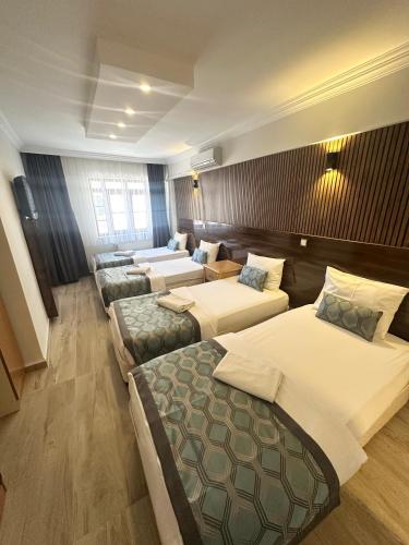 a large room with four beds and couches at CLASS 17 PANSİYON in Canakkale