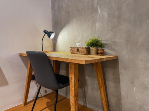 a wooden desk with a chair and a lamp at SNUG Kuta in Kuta