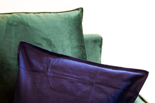 un oreiller violet posé sur une chaise verte dans l'établissement Le Romanée - Très joli studio moderne tout confort proche place Valmy, à Lyon