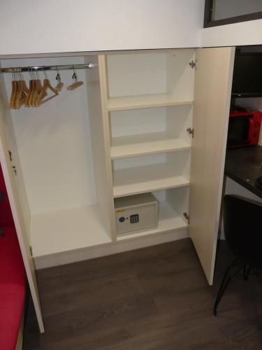 Elle comprend un placard avec des étagères blanches et un bureau. dans l'établissement Le 12 Pierres - Croix-Rousse - Cosy & Design, à Lyon
